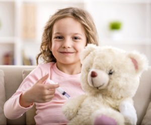 kleines Mädchen impft ihren Teddy mit Spielzeugspritze