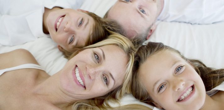 glückliche Familie liegt im Bett