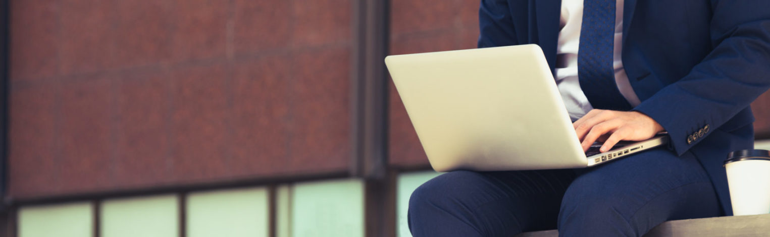 Mann im Businessoutfit mit Laptop